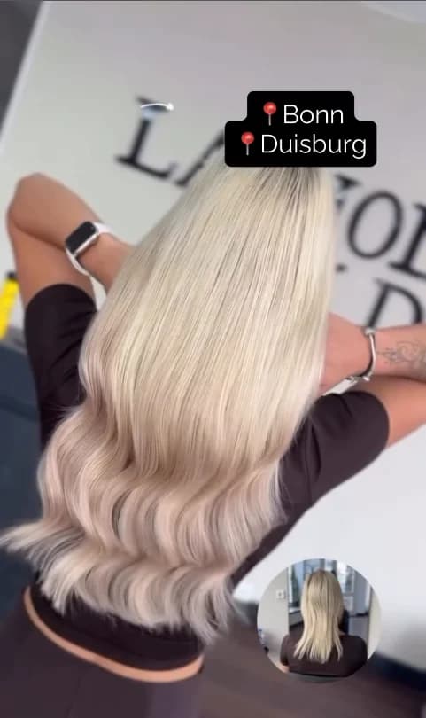 Langes hellblondes Haar mit gleichmäßigen, sanften Wellen.